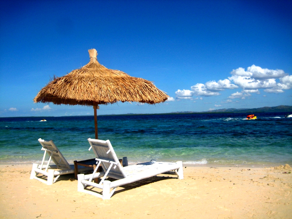 Шезлонги с зонтом на пляже Лавияни
