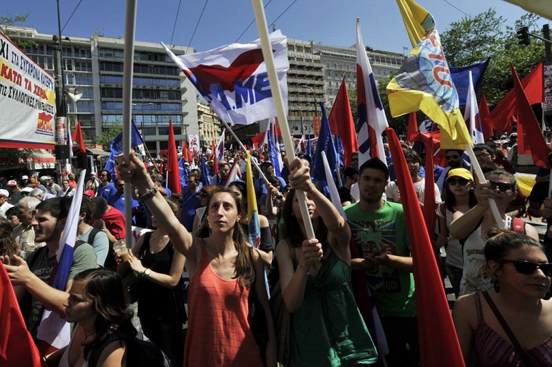 Коммунистически настроенные протестующие держат флаги перед зданием греческого парламента в Афинах.